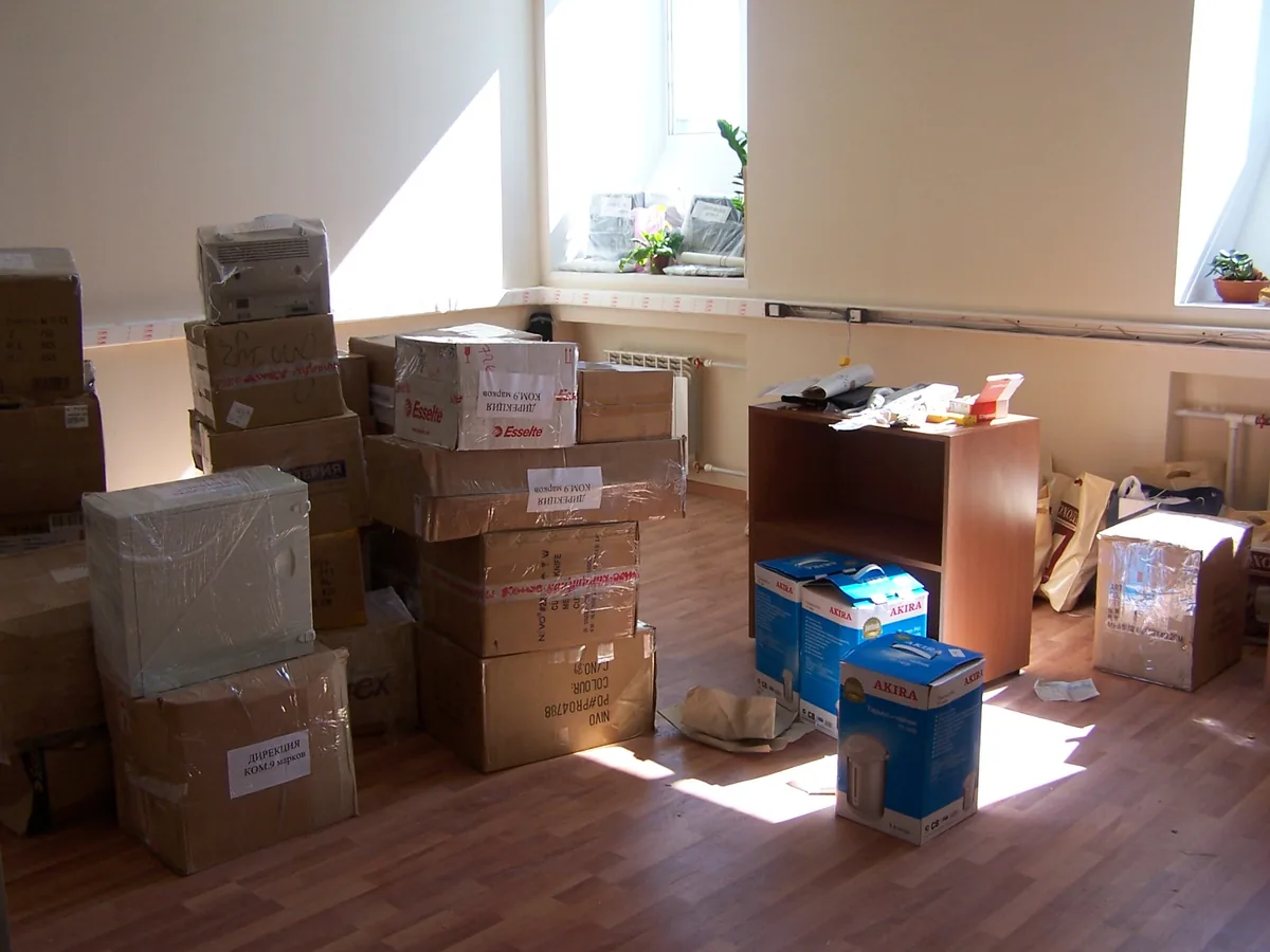Umzugskartons und verpackte Möbel in einem Raum
